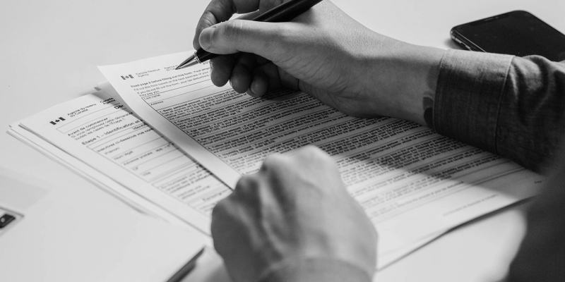 Image of a hand filling out a CRA tax form