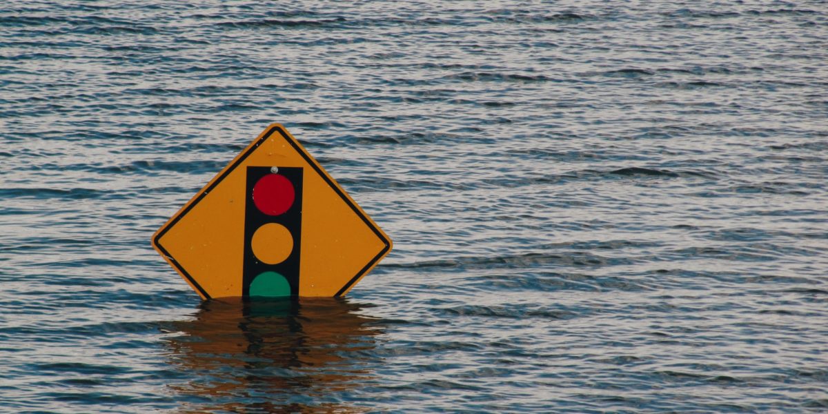 Flood waters rise above street signs.