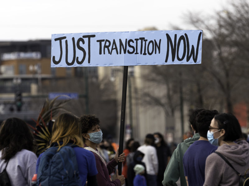 A woman holds a Just Transition Now sign at a rally in Minneapolis, Minnesota. Photo: Lorie Shaull