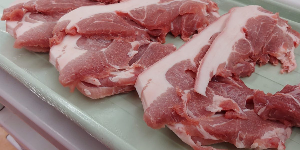 Cuts of raw pork belly on a tray.