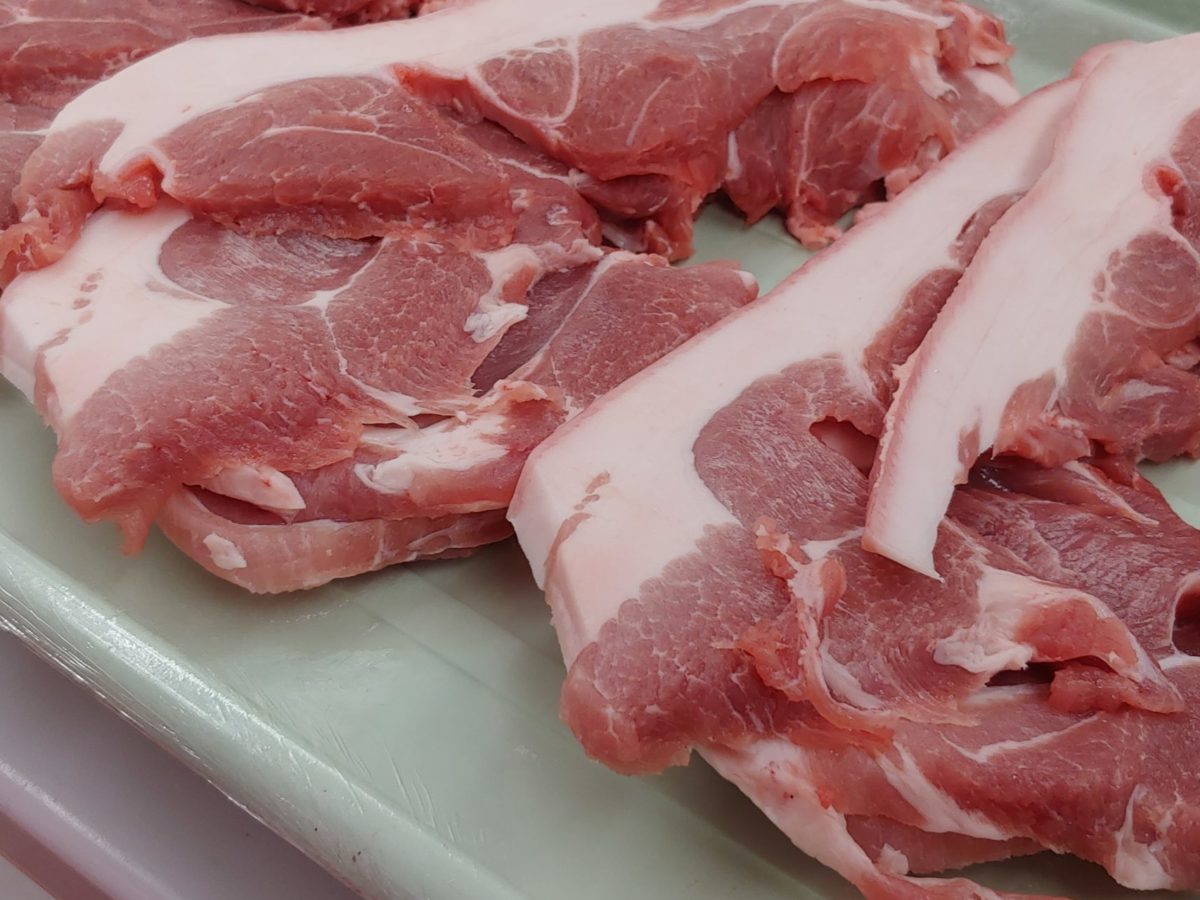 Cuts of raw pork belly on a tray.