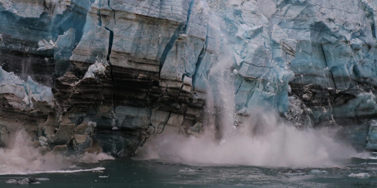 A calving glacier spills ice into the ocean.