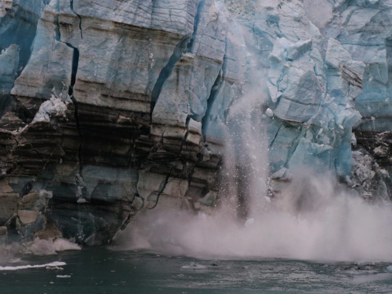 A calving glacier spills ice into the ocean.