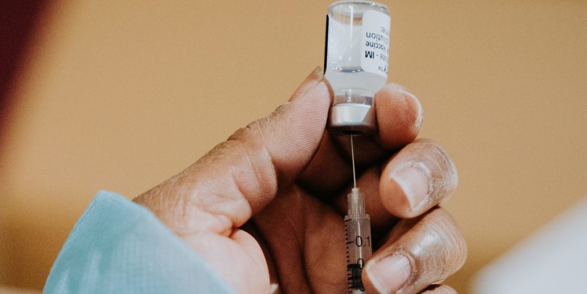 A photo of a health-care worker administers a dose of a COVID-19 vaccine.