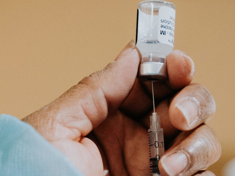 A photo of a health-care worker administers a dose of a COVID-19 vaccine.