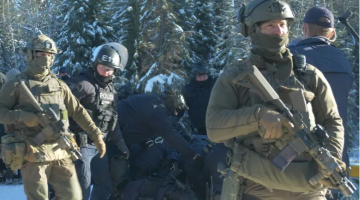 Photo of dozens of heavily armed RCMP breaching the checkpoint during the Nov. 18 militarized raid.