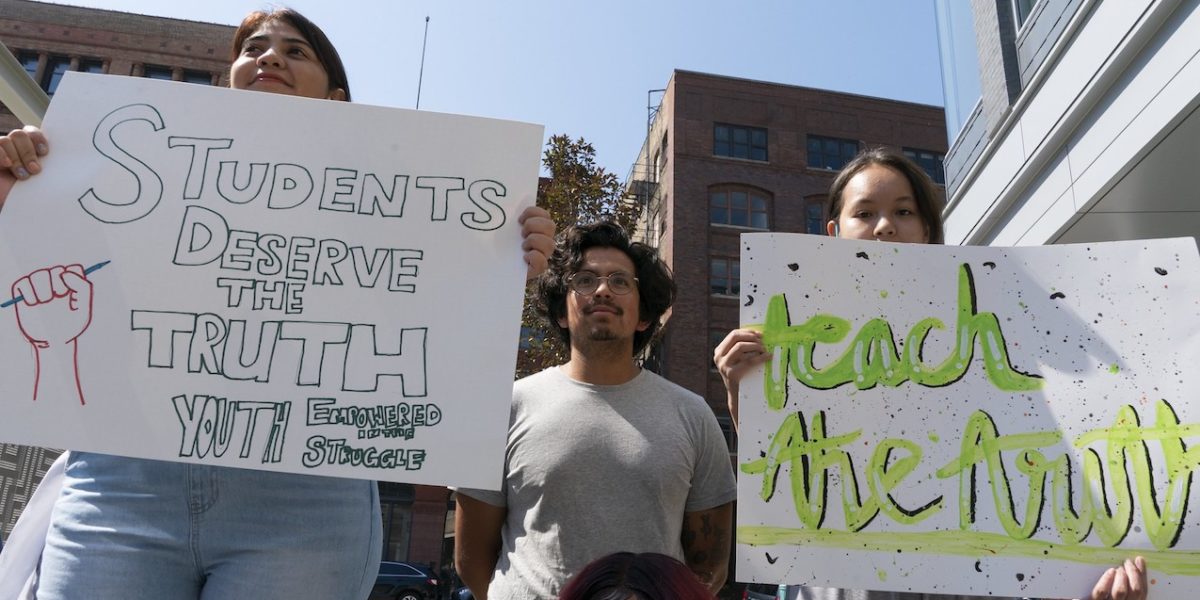 People hold signs at the Milwaukee Teach the Truth rally in June 2021.