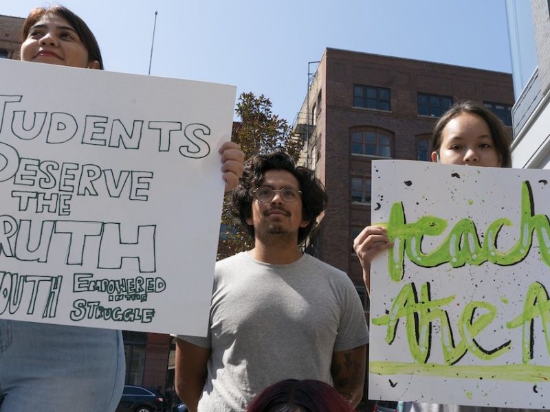 People hold signs at the Milwaukee Teach the Truth rally in June 2021.