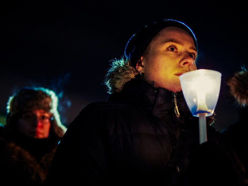 Vigil attendee holds a candle.