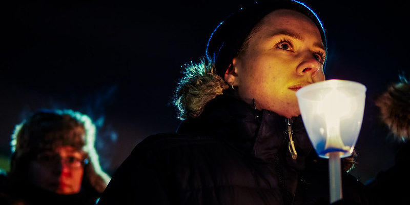 Vigil attendee holds a candle.