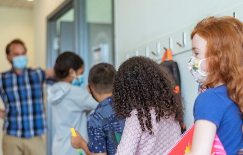 Students and teacher standing in hallway