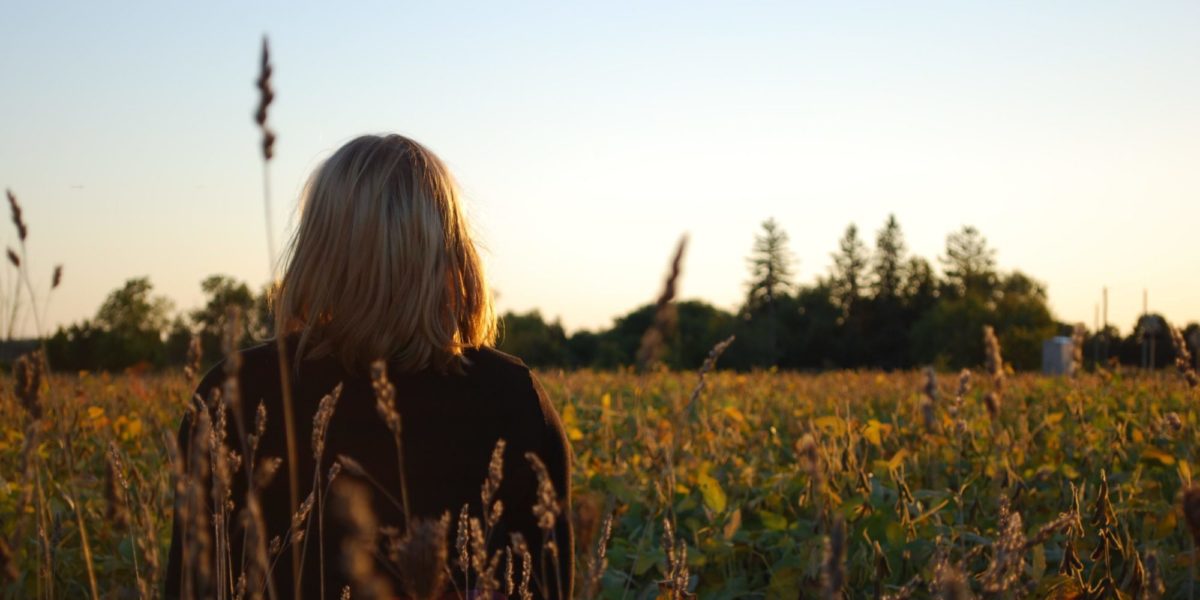 Photo of a girl sitting in rural Ontario farmland.