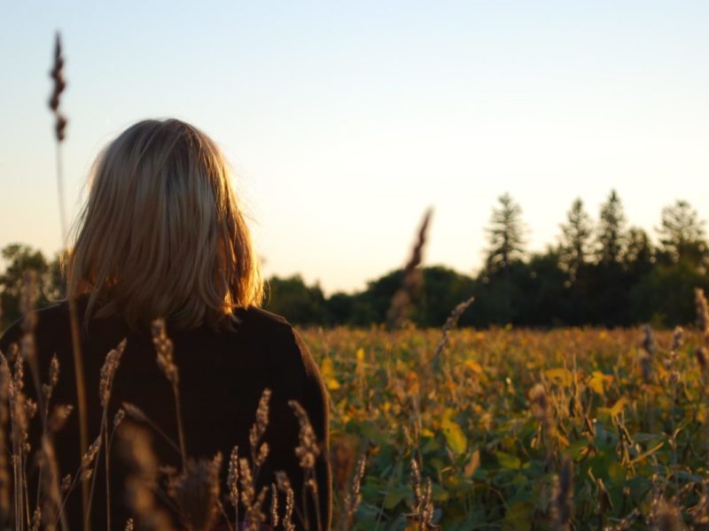 Photo of a girl sitting in rural Ontario farmland.