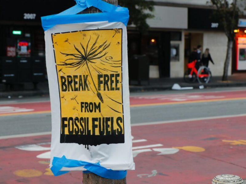 Photo of a poster on a street reading "break free of fossil fuels."
