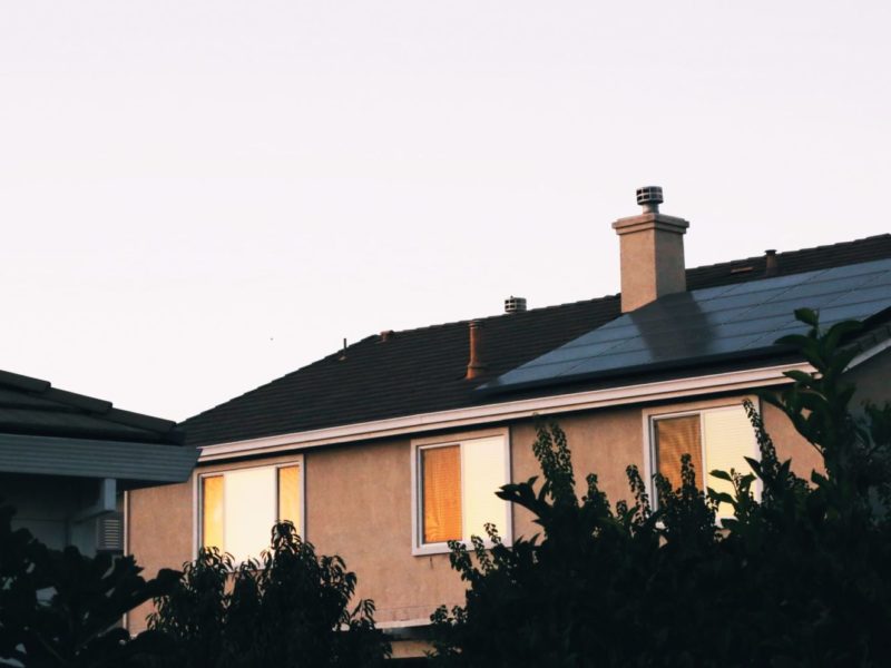 A photo of a house with a solar power panel on the rooftop.