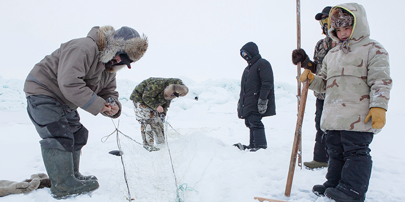 Photo of Inuit ice fishing.