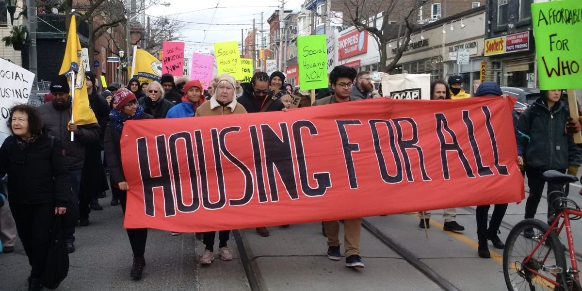 People marching with Housing for All banner.