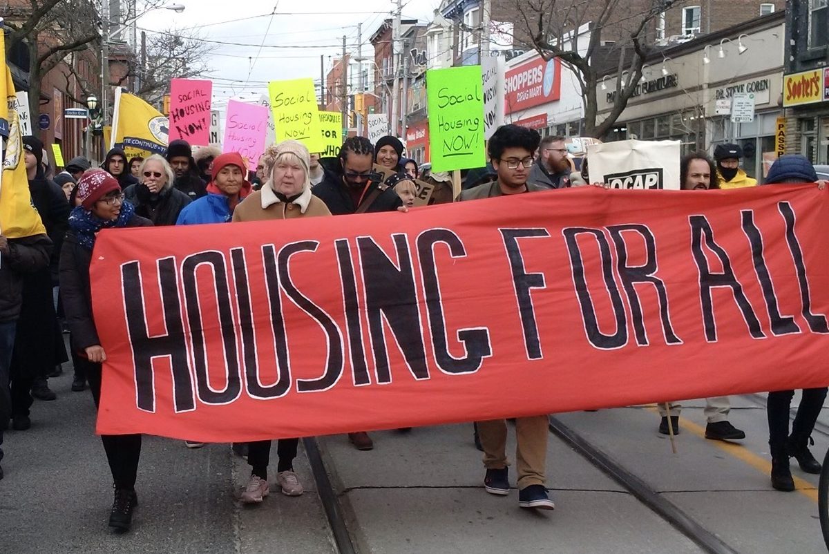 People marching with Housing for All banner.