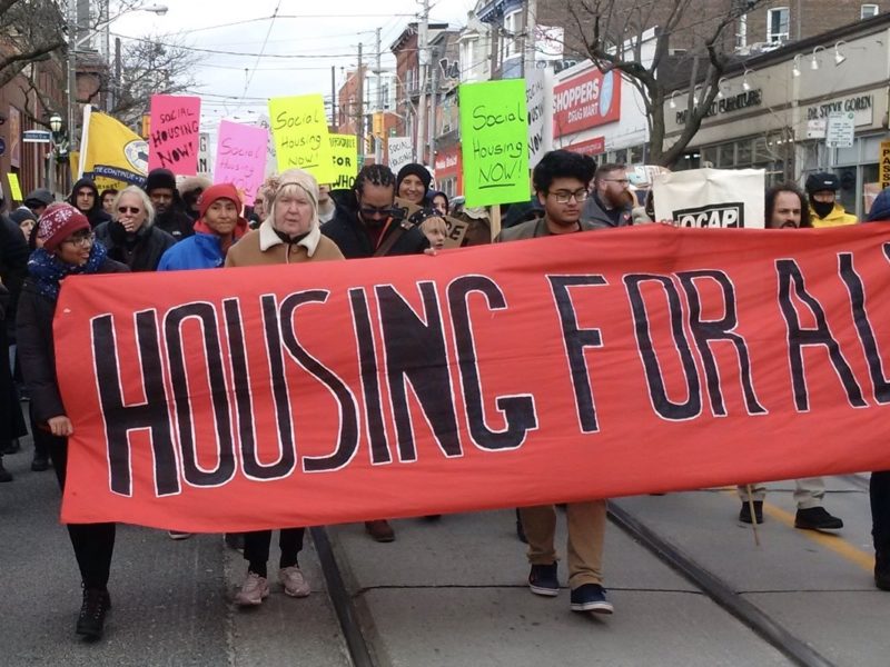 People marching with Housing for All banner.