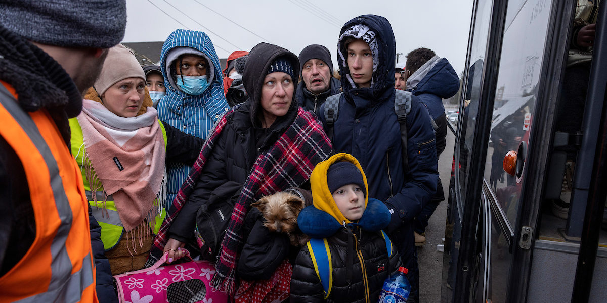 Photo of a group of Ukranian refugees boarding a bus to Poland
