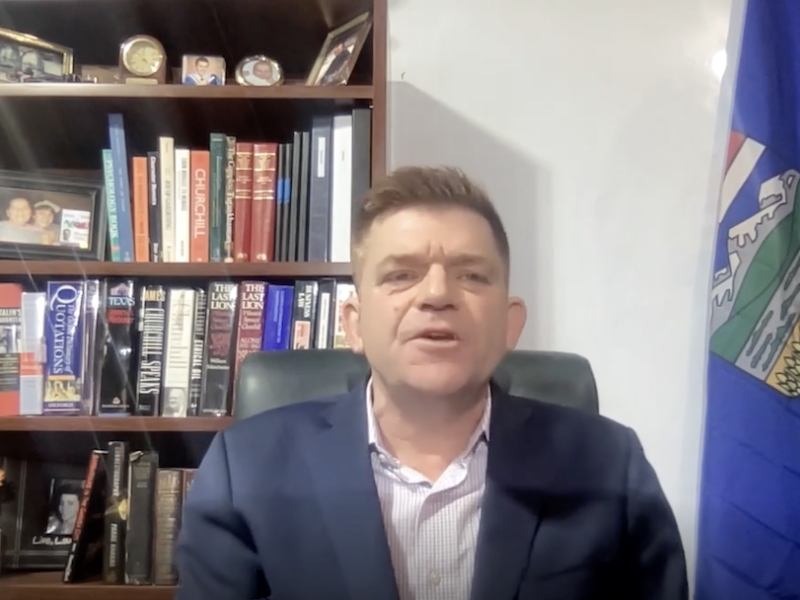 Brian Jean during his statement about the UCP leadership review voting process yesterday – judging from his bookshelf, he shares Jason Kenney’s obsession with Winston Churchill (Photo: Screenshot of Facebook video).