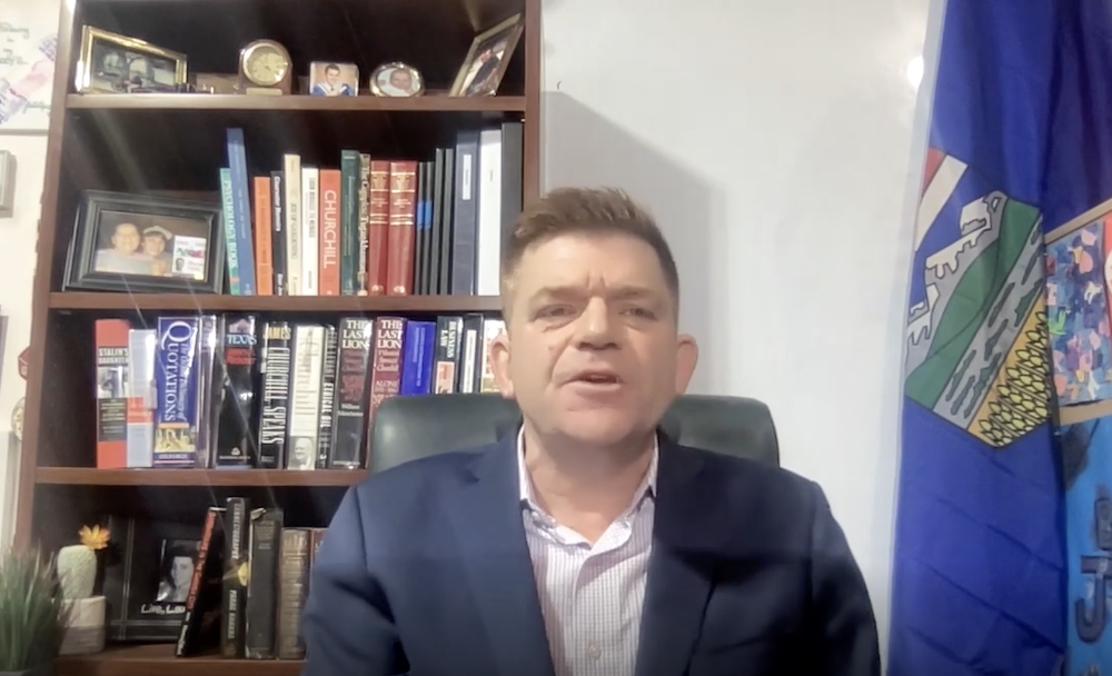 Brian Jean during his statement about the UCP leadership review voting process yesterday – judging from his bookshelf, he shares Jason Kenney’s obsession with Winston Churchill (Photo: Screenshot of Facebook video).