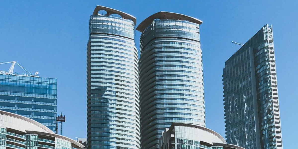 A photo of the top of high rise apartments against a blue sky in Toronto, Canada.