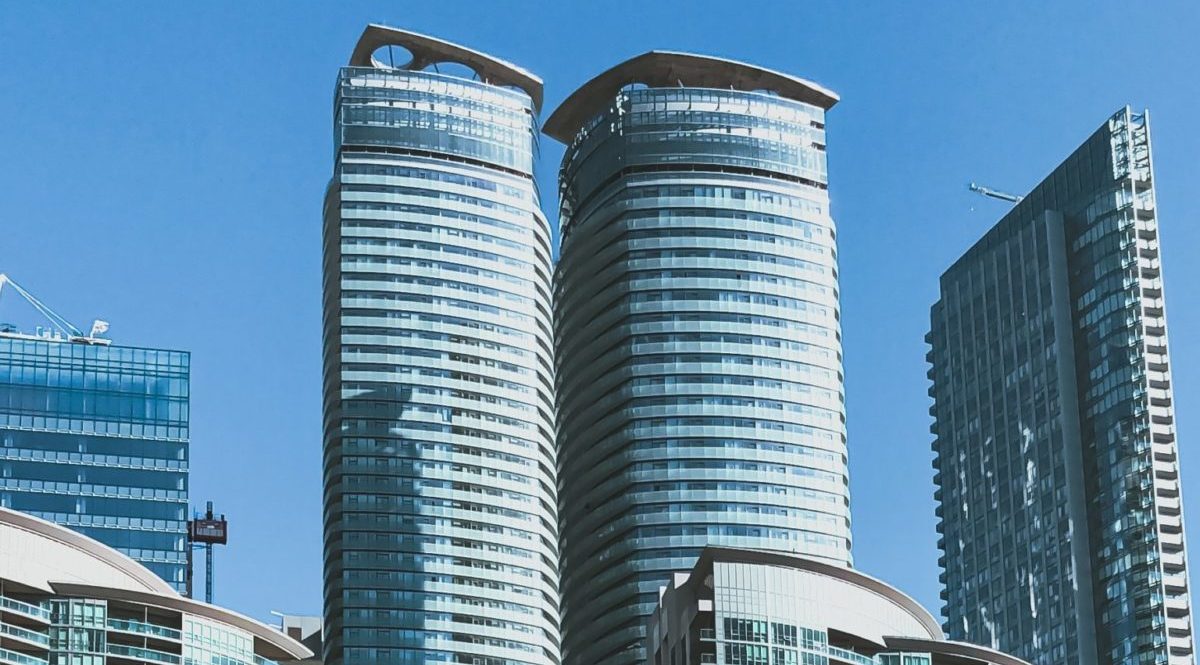 A photo of the top of high rise apartments against a blue sky in Toronto, Canada.