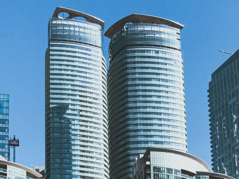 A photo of the top of high rise apartments against a blue sky in Toronto, Canada.