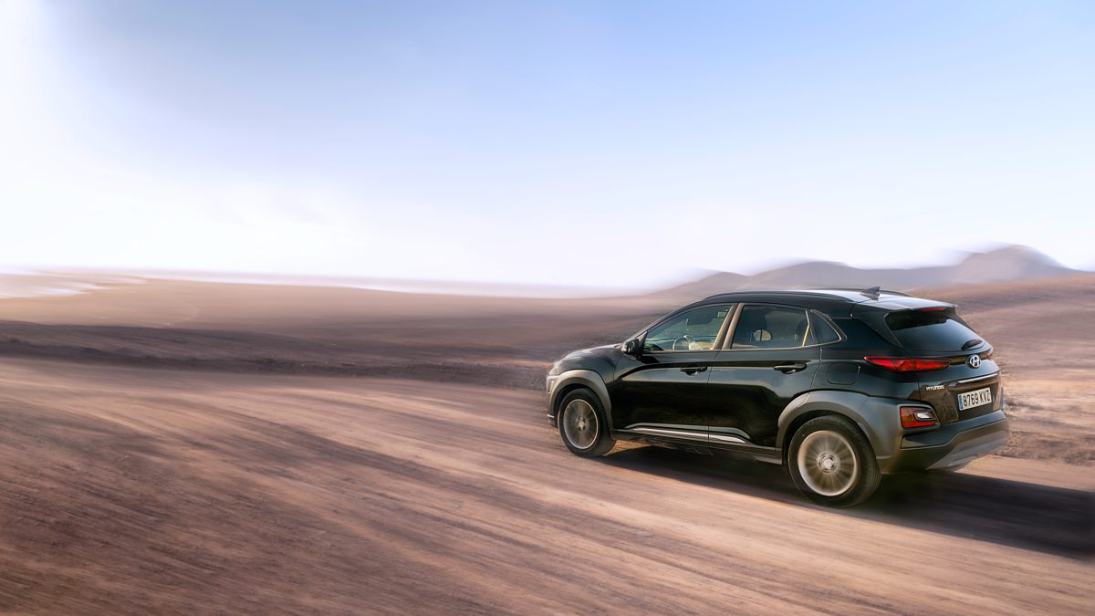 An SUV driving down an unpaved road.