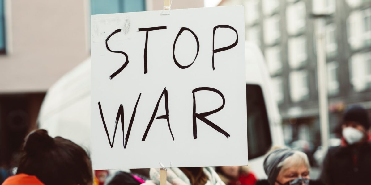 Photo of a sign being held at an anti-war protest which reads "STOP WAR"