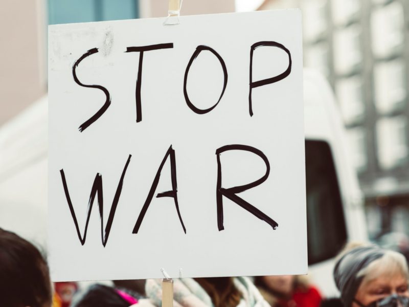 Photo of a sign being held at an anti-war protest which reads "STOP WAR"