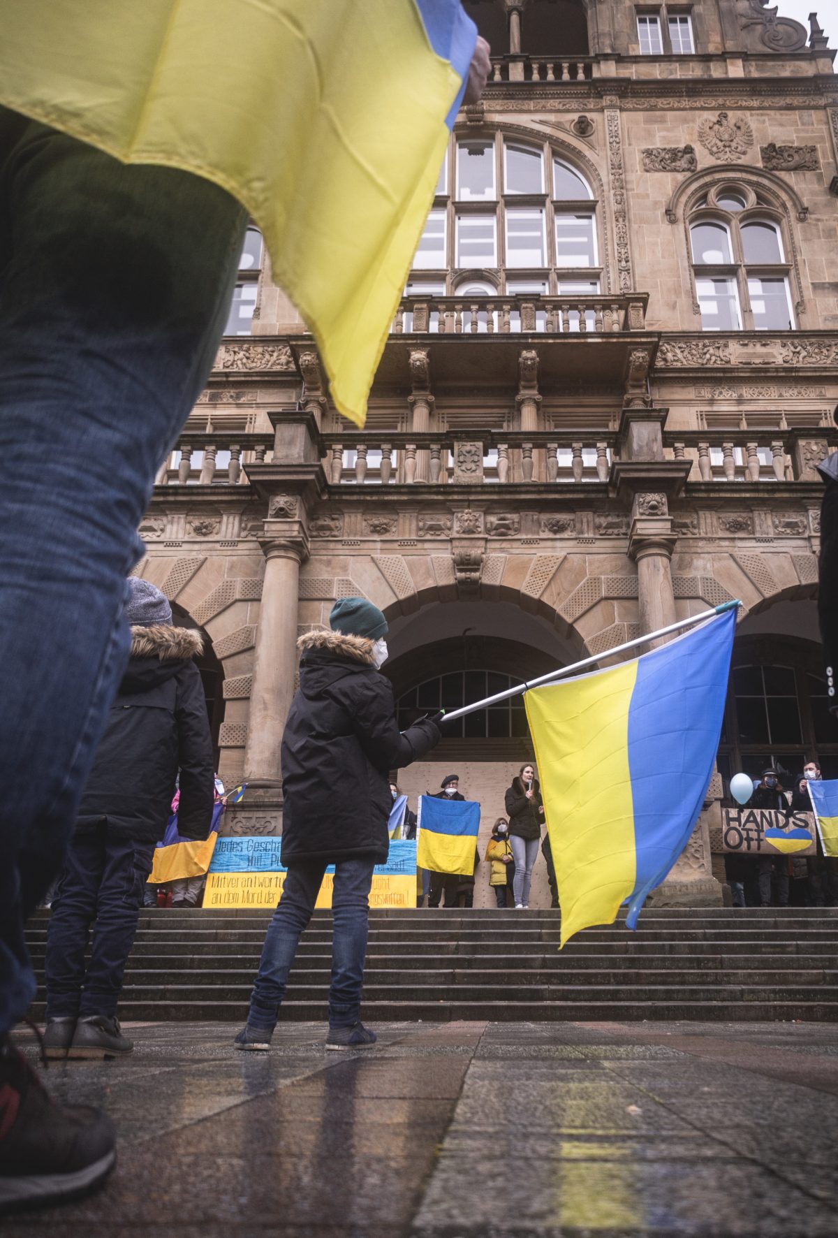 A young boy waving a Ukrainian flag in the center of a demonstration showing solidarity with Ukraine and the Ukrainian people in Bielefeld, Germany.