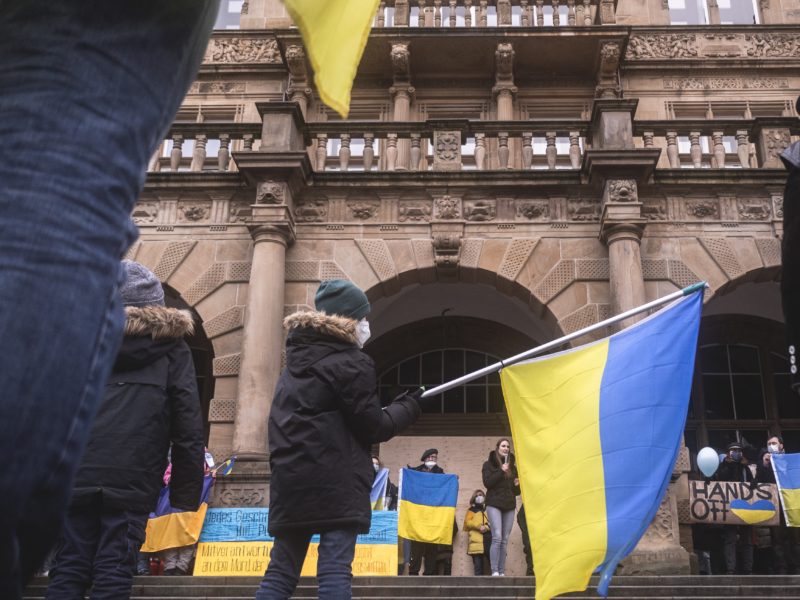 A young boy waving a Ukrainian flag in the center of a demonstration showing solidarity with Ukraine and the Ukrainian people in Bielefeld, Germany.