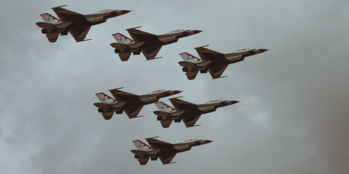 Photo of six fighter jets flying in the sky in a 'v' formation.