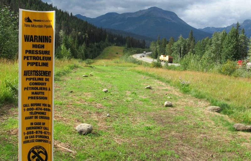 A photo of a sign warning of high pressure oil passing through the TransMountain pipeline. On Earth Day, Rita Wong is asking readers to consider ways of healing the land.