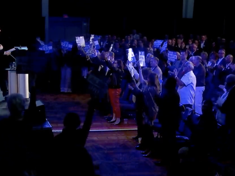 A screenshot of Alberta Premier Jason Kenney addresses a carefully curated crowd of about 100 supporters at yesterday’s UCP “Special General Meeting” in Red Deer. Kenney's leadership review has divided the party (Photo: Screenshot of United Conservative Party video).