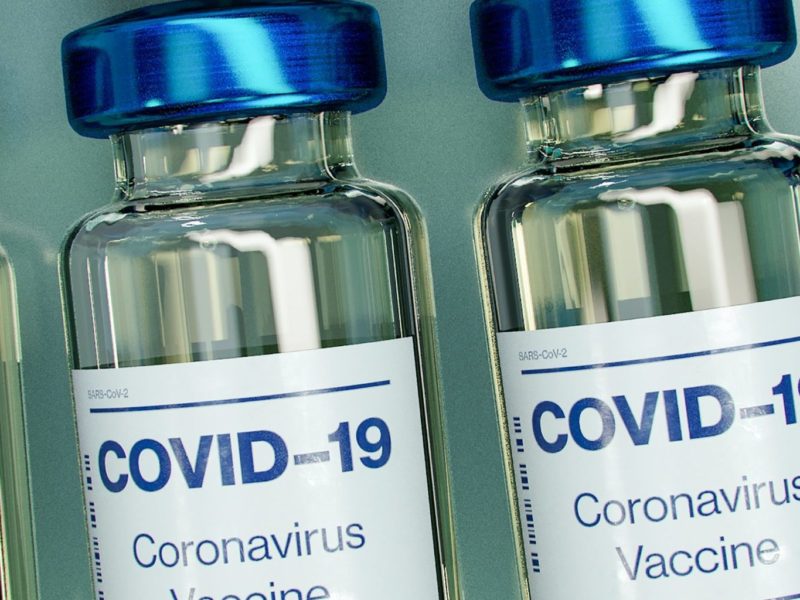 A photo of a blue and white covid-19 vaccine bottle mockup.