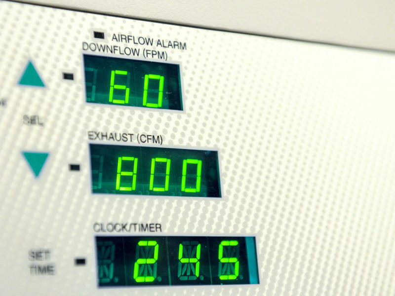 A photo of lab equipment measuring numbers like airflow, exhaust and time.