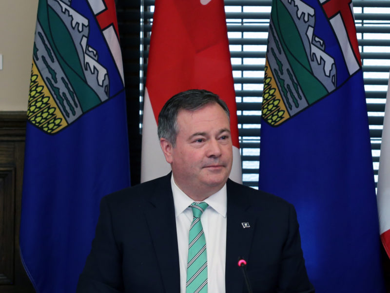 Jason Kenny sitting with Alberta and Canada flags behind him at a cabinet meeting on May 20, 2022 days after resigning