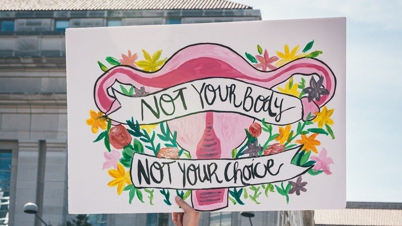 Photo of a sign reading abortion not your body not your choice.