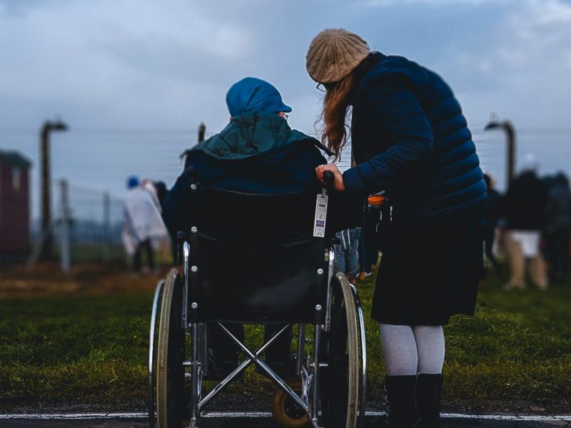 A photo of a person in a wheelchair and another person standing beside them