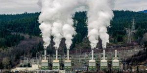 A photo of carbon emissions being released into the atmosphere from industrial smoke stacks.