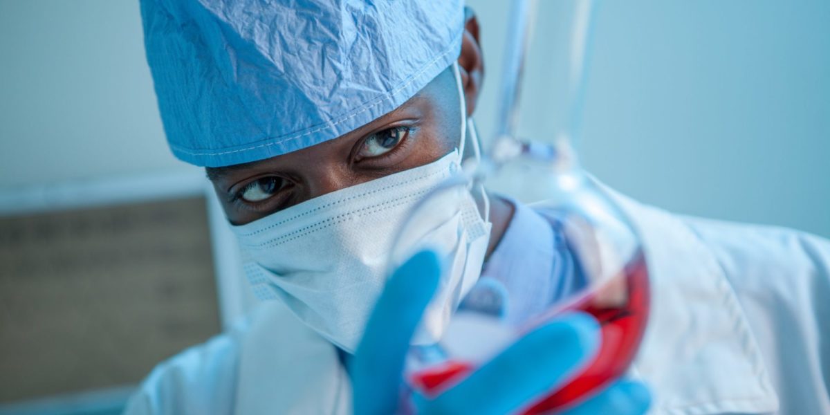 Photo of a doctor looking into a test tube.