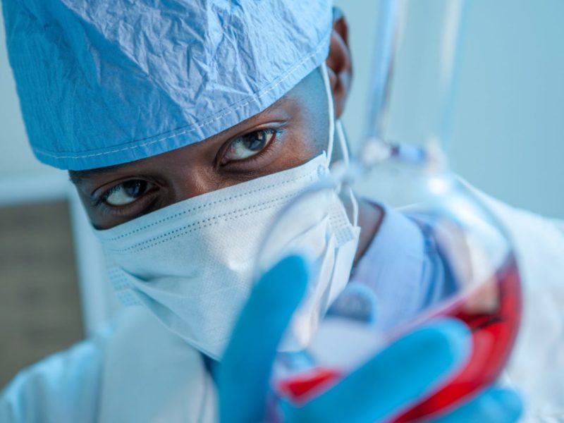 Photo of a doctor looking into a test tube.