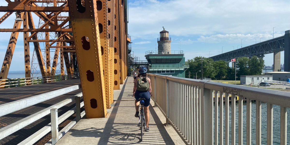 Cyclist riding on bike lane next to a bridge.