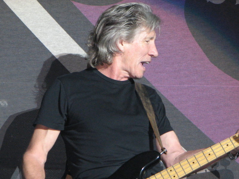 A photo of rock star Roger Waters performing on stage.