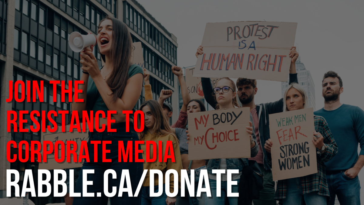 A photo of protestors with 'join the resistance' for media democracy text