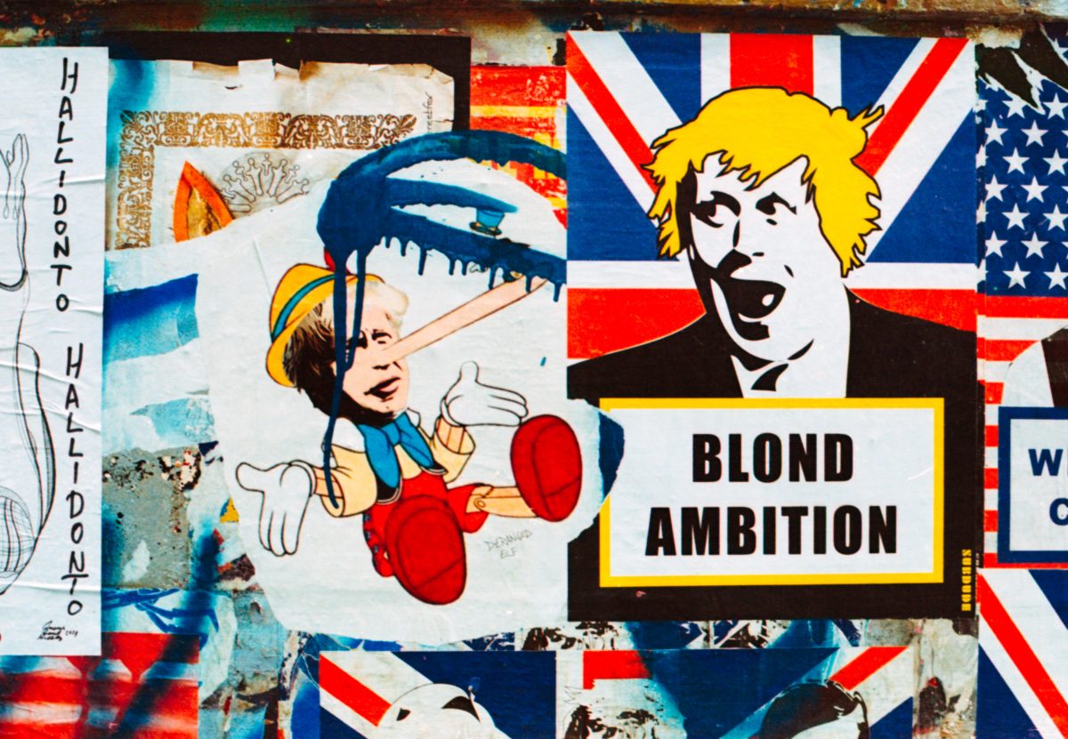 A photo of a wall of graffiti featuring Boris Johnson art