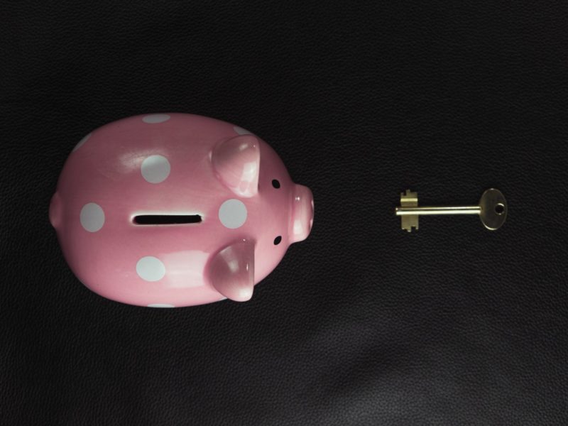 A photo of a piggy bank and a key to open it laying in front of him.
